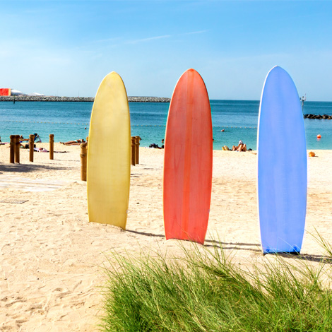 surf boards sticking out of the beach