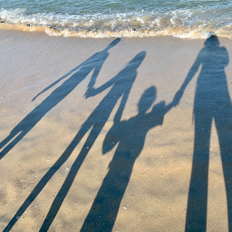 shadows of a family on the beach