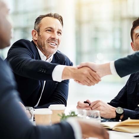 Shot of businesspeople shaking hands during a meeting in an office