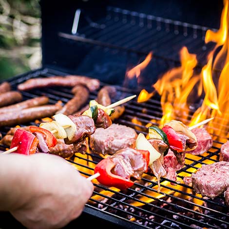 Detail Of Beef Burgers and sausages Cooking On A Barbecue