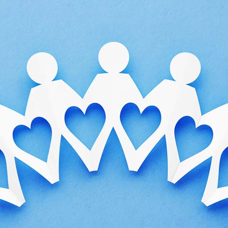 paper cutout of people holding hands and heart shape