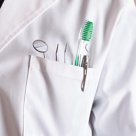 White coat of dentist with tools in his pocket White coat of dentist with tools in his pocket. Horizontal composition. Front view.