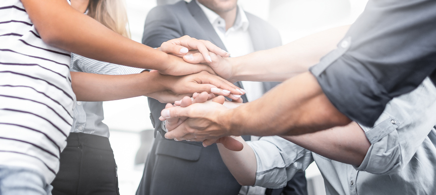 Close up view of young business people putting their hands together. Stack of hands. Unity and teamwork concept.