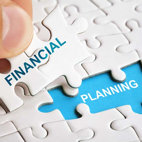 Hand holding piece of puzzle with words Financial Planning. Puzzle pieces with words financial planning