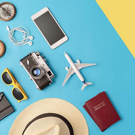 High angle view of travel accessories on the blue/yellow background with copy space