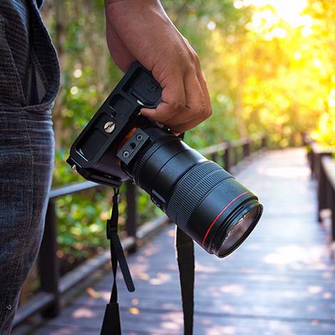 Man holding his camera on walkway during his travel