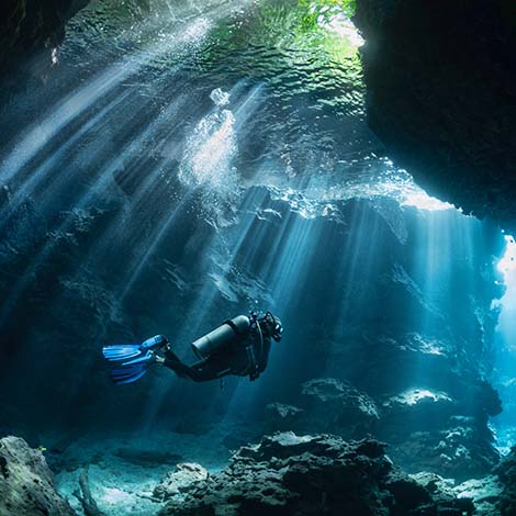 Scuba Diver in Shallow Lagoon Beautiful light beams through the jungle canopy then into this cavern system.