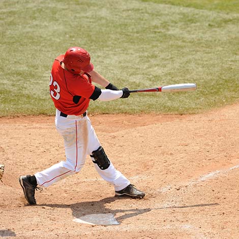 A Baseball play hits a ball during a game.