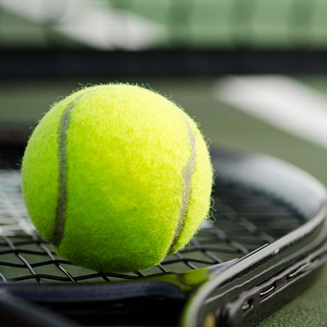 Tennis Ball and Racket on the Court Horizontal tennis ball on racquet on tennis court