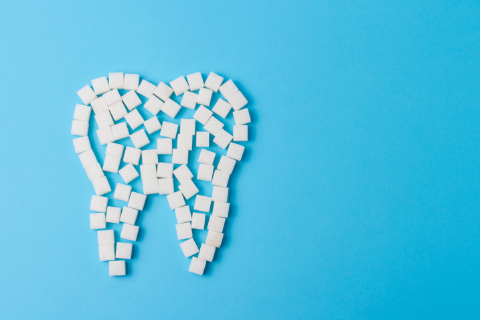 Various white puzzle pieces placed to make a tooth on a blue background