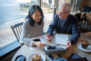 Asian Woman, Senior Man Reviewing Financial Information on Digital Tablet