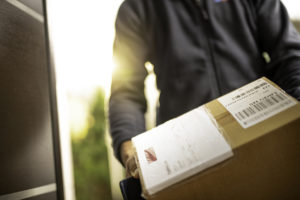 Courier holding cardboard box for delivery