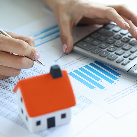 Model house and calculator sitting on top of papers