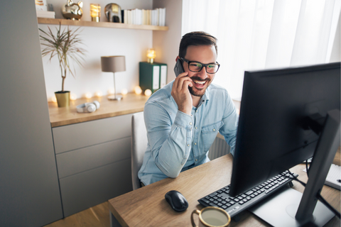 Man wearing glasses on the phone in his home office