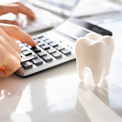 GregRobbins-WorkWith Plastic tooth next to a calculator