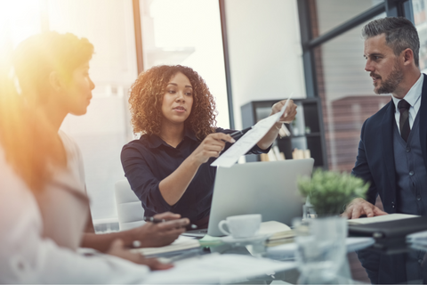 Corporate meeting where 3 individuals review documents