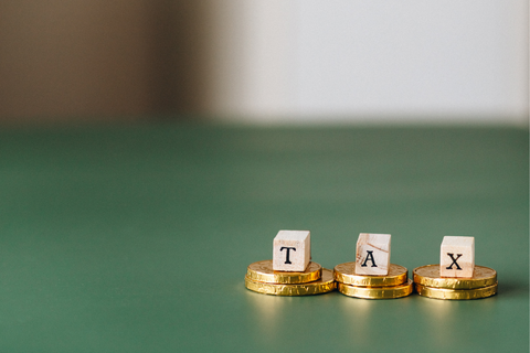 Tax spelled out using wooden blocks on top of coins