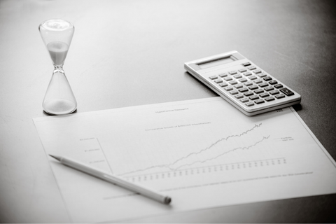 hour glass calculator and chart on a grey table