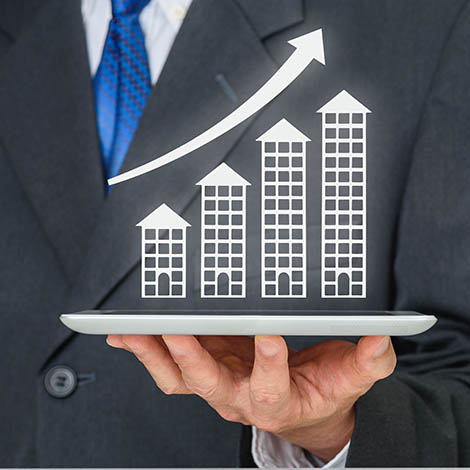 Developer with a tablet and increasing height buildings conceptual image Real Estate moguls