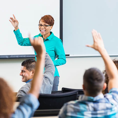Female professor taking questions after lecture in college classroom decorative