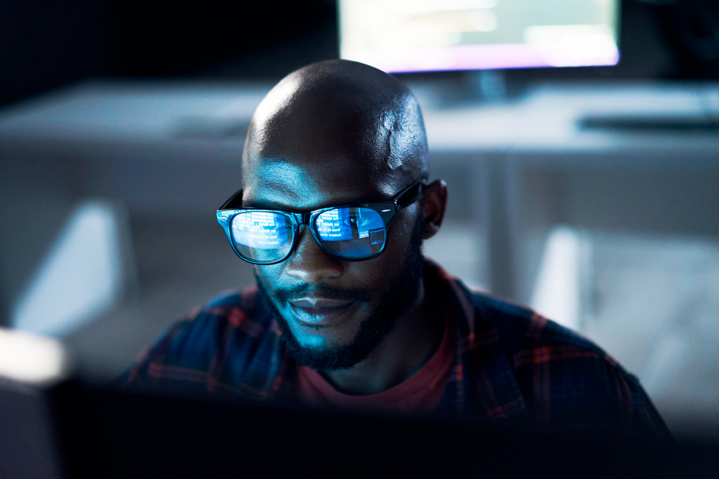 Person with glasses looking at a computer screen