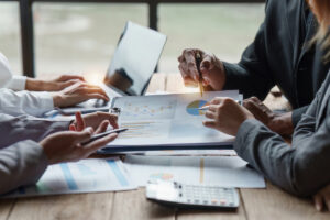 Group of businesspeople going over financial charts on paper background image