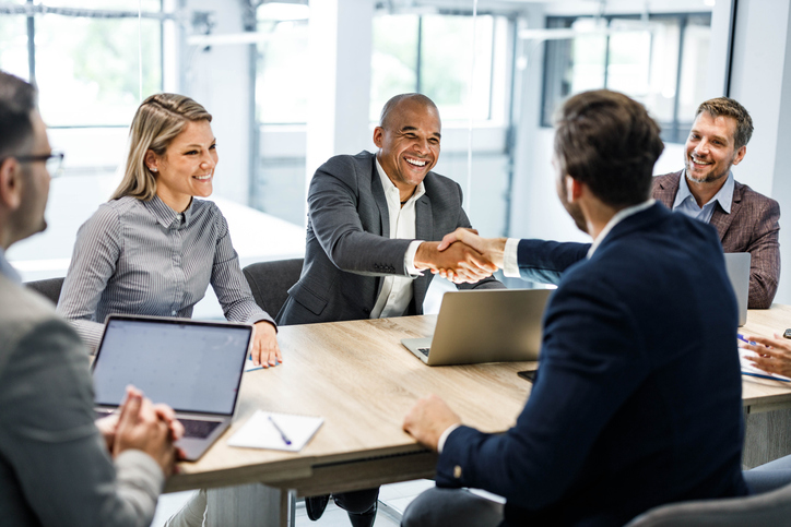 Happy businessmen shaking hands on a meeting in the office. Happy businessmen shaking hands on a meeting in the office.