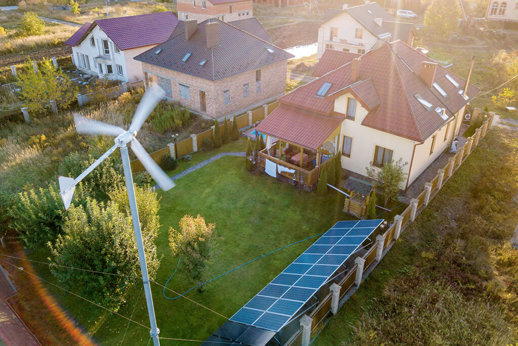 Residential houses with solar panels and wind generator turbine