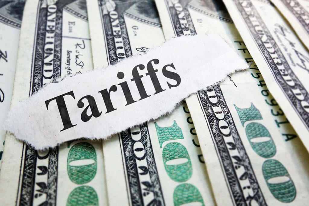 Tariffs newspaper headline on money - stock photo