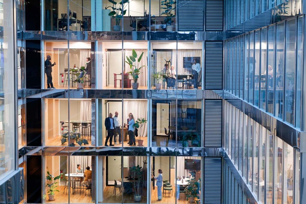 Businessmen and businesswomen working in several offices and on several floors in a modern building of a company - stock photo