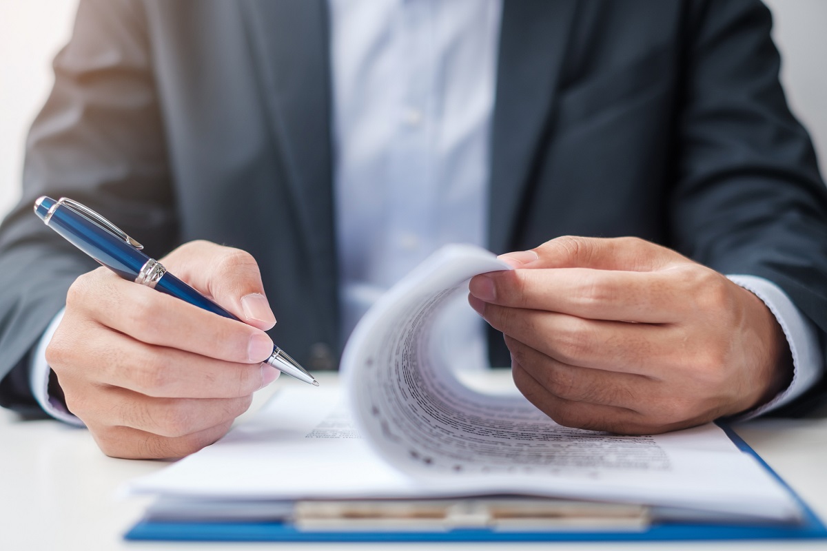 Businessman signing on contract documents after reading, man holding pen and approve on business report. Contract agreement, partnership and deal concepts - stock photo