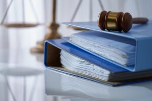 Gavel hammer on stack of document libra scale as background