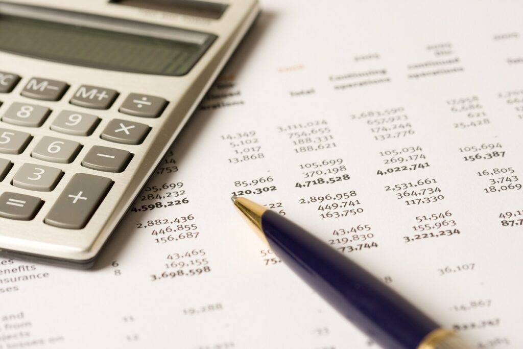 Calculator and pen on stack of financial documents