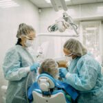 Orthodontist doing professional cleaning of female patient's braces