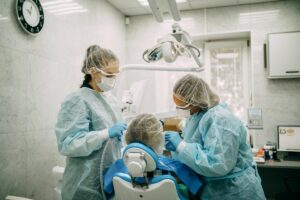 Orthodontist doing professional cleaning of female patient's braces