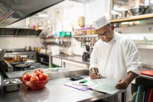 A chef is balancing the accounts in the kitchen