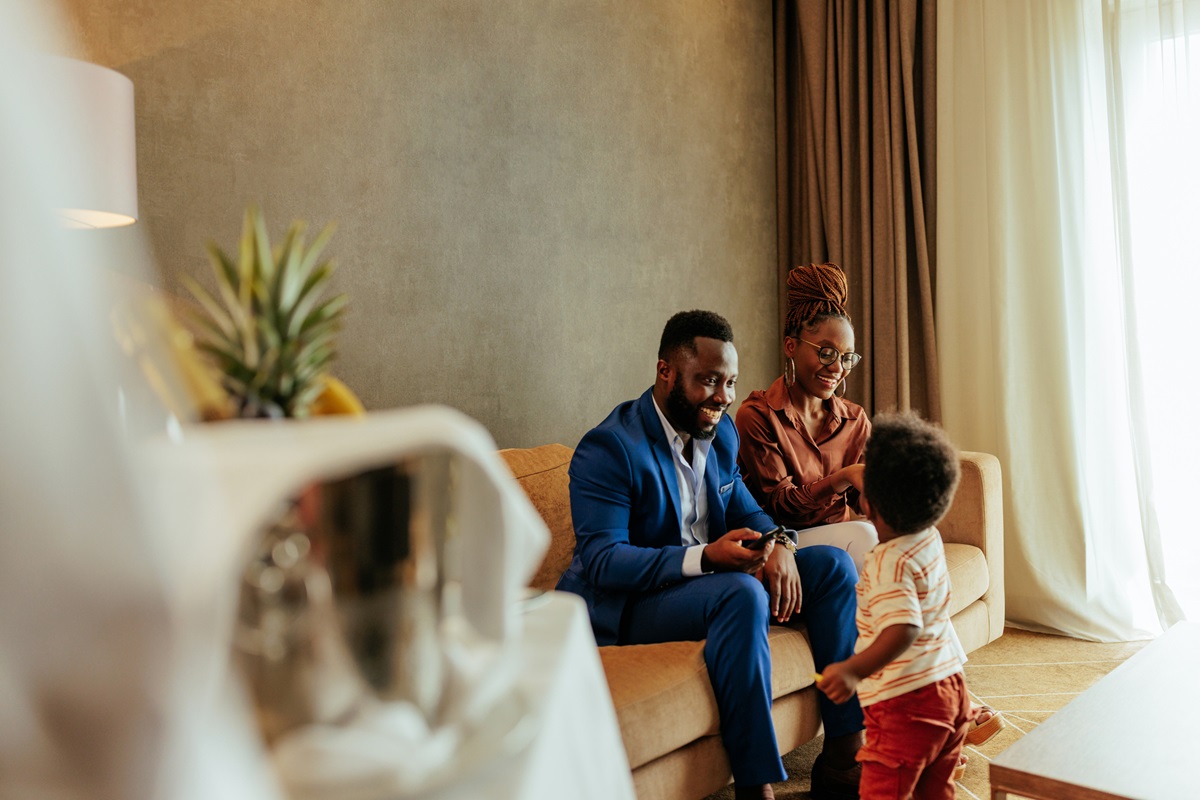 A family of wealthy African Americans are traveling and staying at a fancy hotel enjoying their time together and with expensive room service.