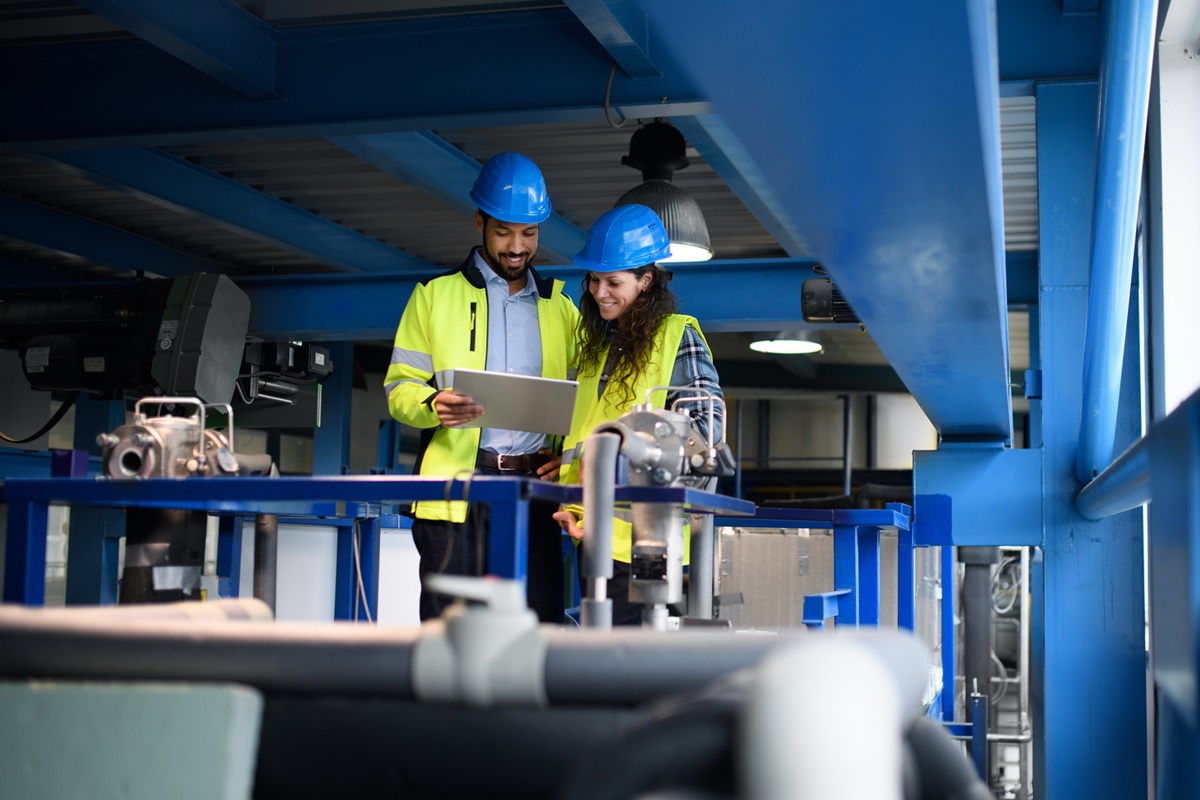 Young african-american man working with his woman colleague in warehouse, showing something.