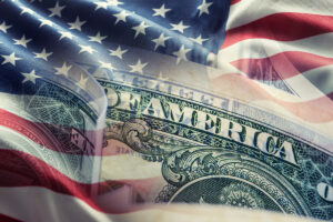 American flag and dollar banknotes - business background.
