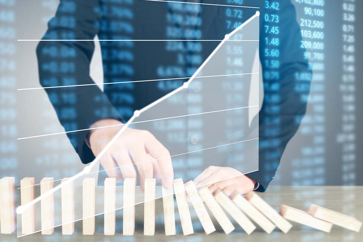 Person stacking wooden blocks like dominos beneath a digital white graph and a blue numbers crawl