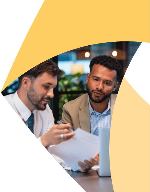 In a corner of the Aprio pinwheel logo, two men sit in an office and review a piece of paper