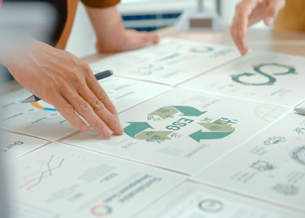 Close up of someone touching an array of paper certificates with environmental messaging on them