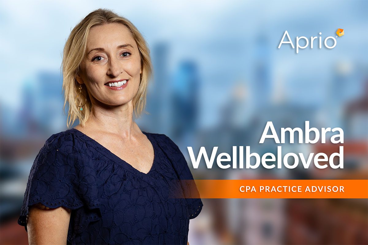 A woman stands smiling in front of a blurred cityscape background. Text reads Aprio Ambra Wellbeloved, CPA Practice Advisor.