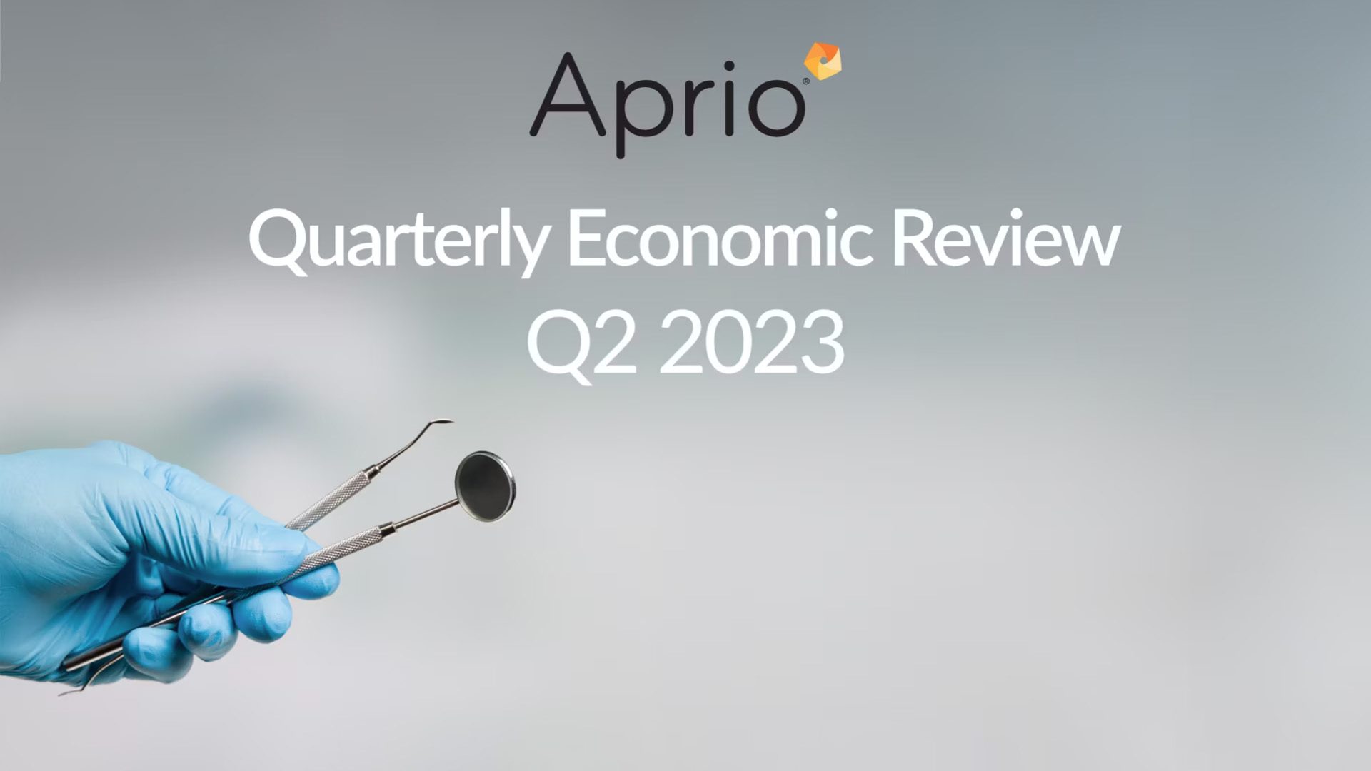 A gloved hand holds dental tools with the Aprio logo and text reading Quarterly Economic Review Q2 2023 on a blurred background.