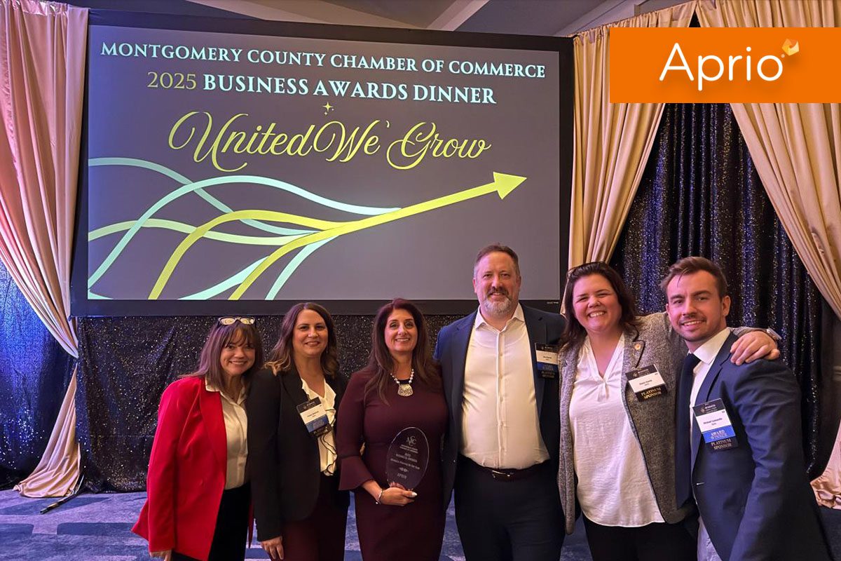 Six people pose together at the Montgomery County Chamber of Commerce 2025 Business Awards Dinner, with an event banner and the Aprio logo in the background.
