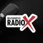 A black microphone next to the Business RadioX logo on a dark background.