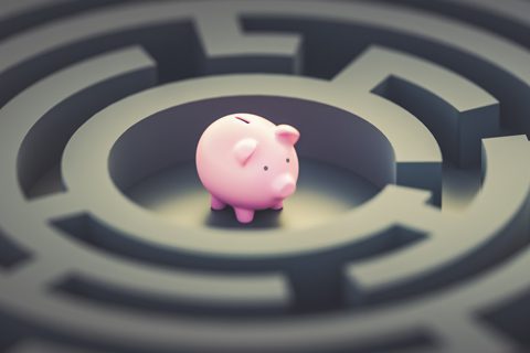 A pink piggy bank sits at the center of a circular maze with high walls, symbolizing financial challenges or decision-making.