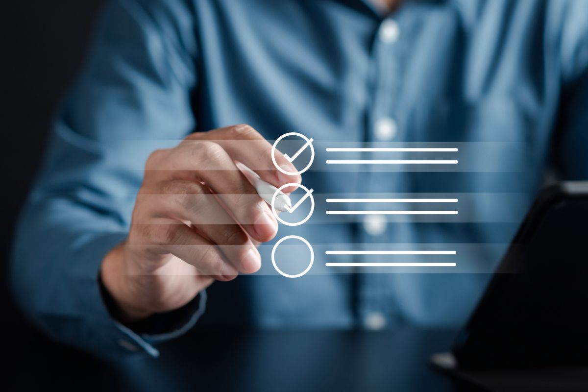 A person selects a checklist item on a transparent virtual interface, with a tablet in the background.