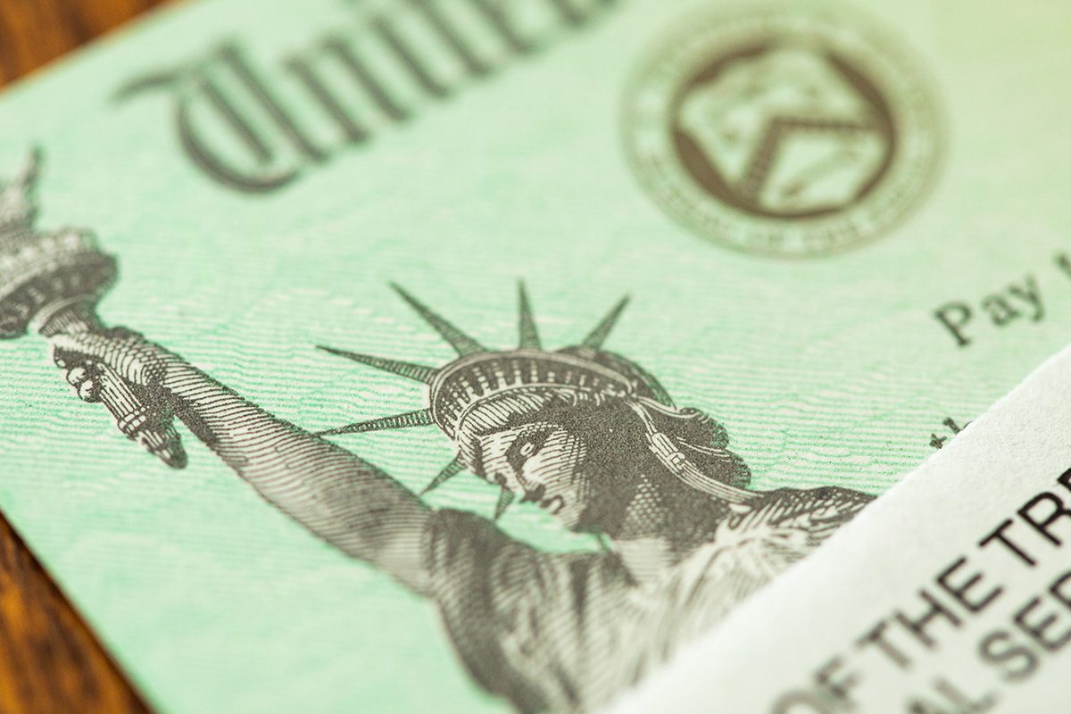Close-up of a U.S. Treasury check featuring part of the Statue of Liberty illustration and the word United at the top.