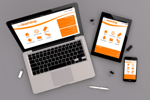 A laptop, tablet, and smartphone display the same e-learning website interface with orange and white colors, placed on a gray surface with a pen and USB drives.